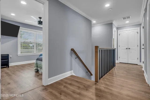 a view of a hallway with wooden floor and entryway