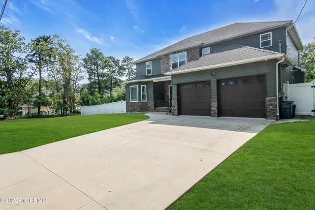 a front view of a house with a yard and potted plants