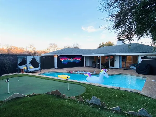 a view of a house with backyard and sitting area