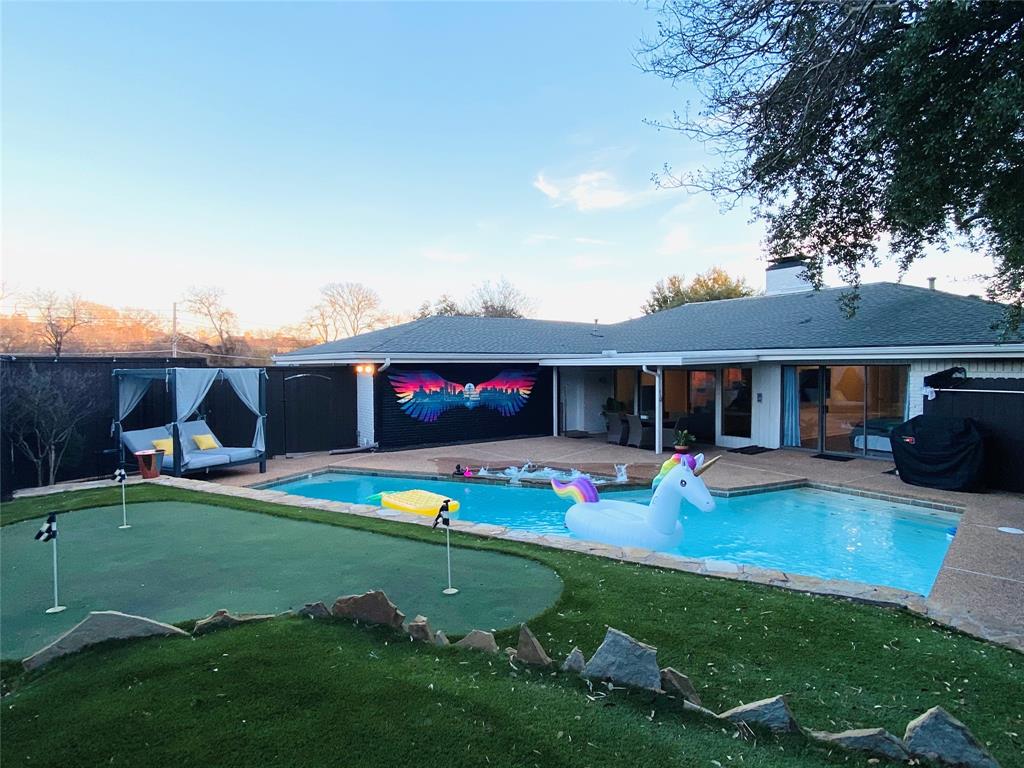 a view of a house with backyard and sitting area