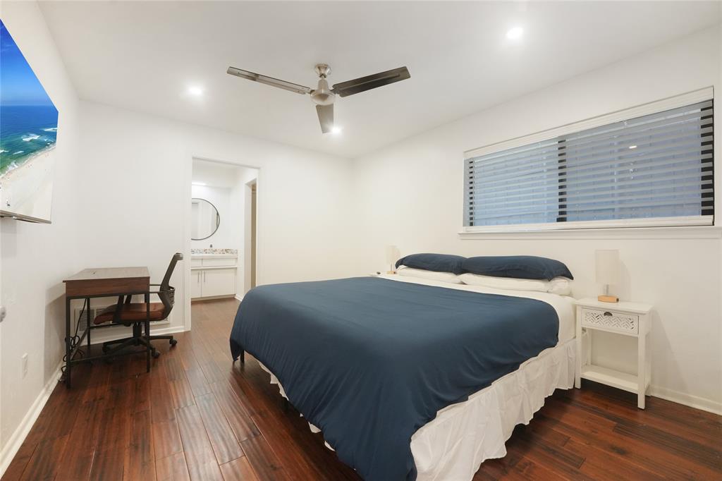 9677 Fallbrook Drive Dallas, TX 75243 - Photo 19 of 40 a bedroom with a bed wooden floor and a table
