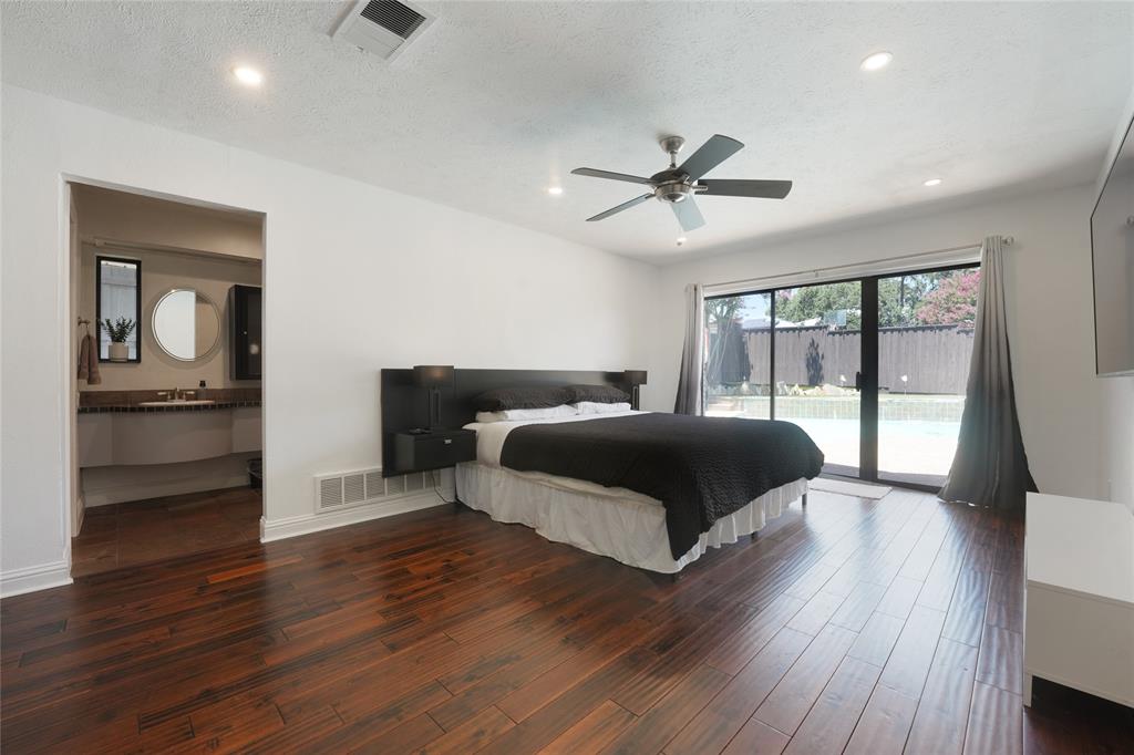 9677 Fallbrook Drive Dallas, TX 75243 - Photo 21 of 40 a bedroom with a bed and wooden floor
