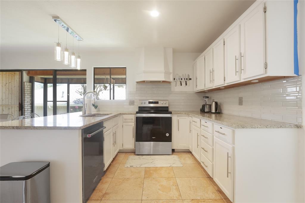 9677 Fallbrook Drive Dallas, TX 75243 - Photo 32 of 40 a kitchen with stainless steel appliances granite countertop a stove and cabinets