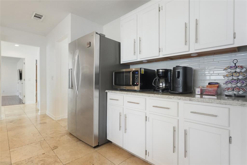 9677 Fallbrook Drive Dallas, TX 75243 - Photo 36 of 40 a kitchen with stainless steel appliances granite countertop white cabinets and a refrigerator