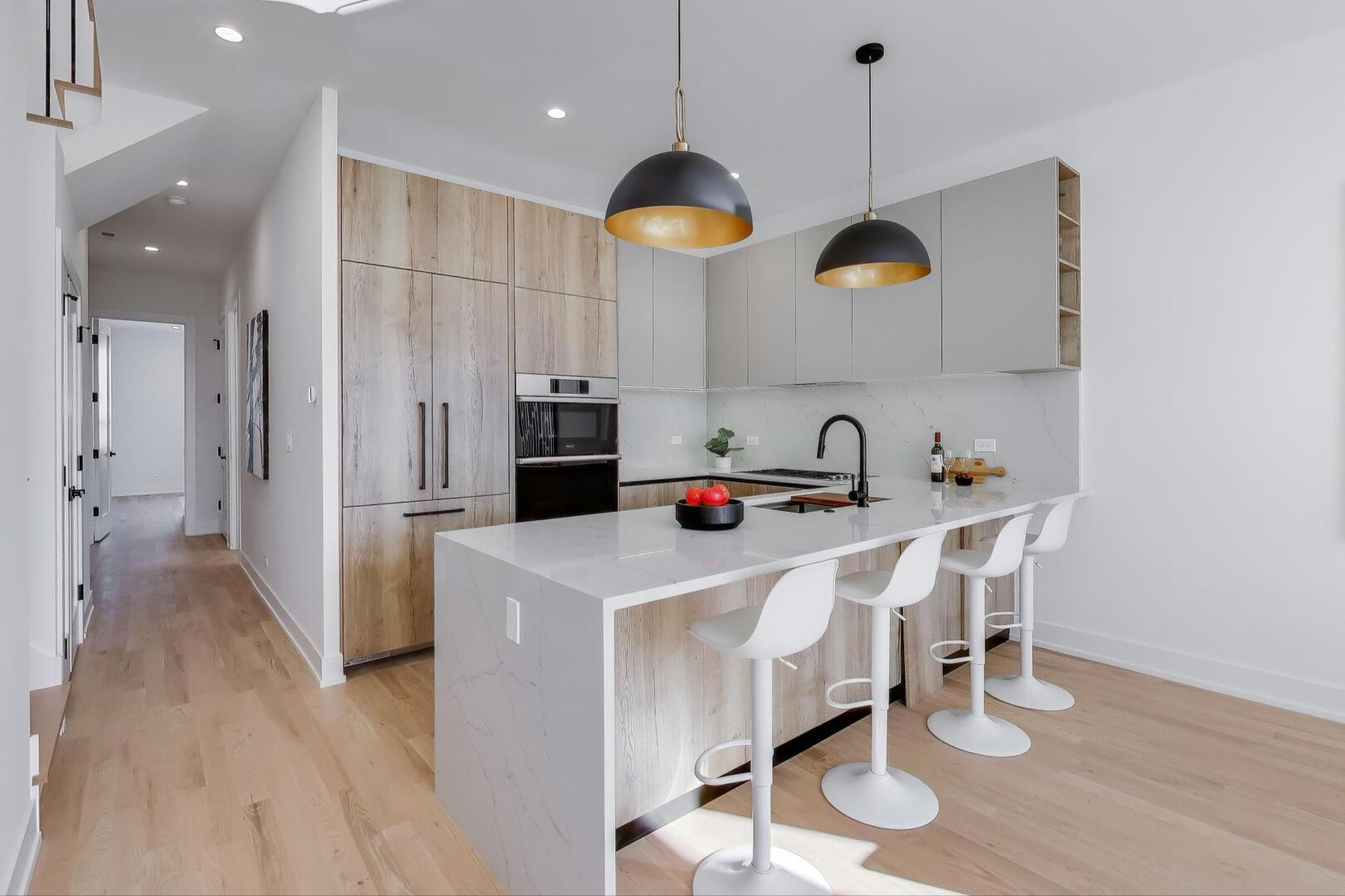 2456 West Cortez Street, Unit 3E Chicago, IL 60622 - Photo 13 of 46 a kitchen with kitchen island stainless steel appliances granite countertop a stove a sink a dining table and chairs with wooden floor