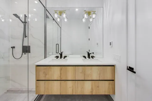 a bathroom with a double vanity sink mirror and shower