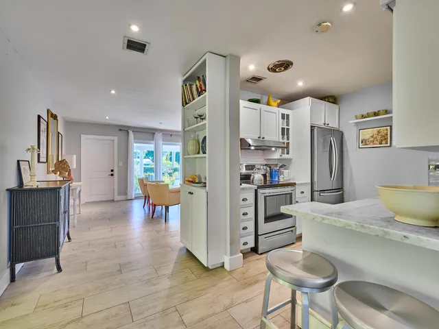 a kitchen with stainless steel appliances kitchen island granite countertop a refrigerator and a stove top oven