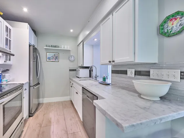 a kitchen with stainless steel appliances a sink stove and refrigerator