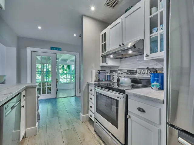 a kitchen with stainless steel appliances granite countertop a stove a sink and white cabinets