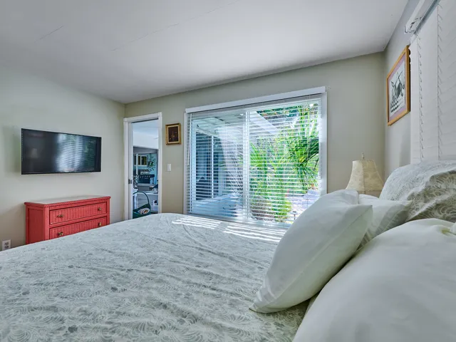 a bedroom with a large bed and a flat screen tv