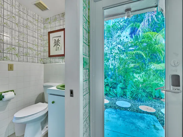 a white toilet sitting next to a shower curtain