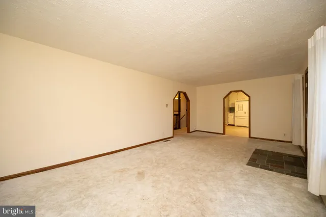 a kitchen with stainless steel appliances a sink a stove a refrigerator cabinets and a window