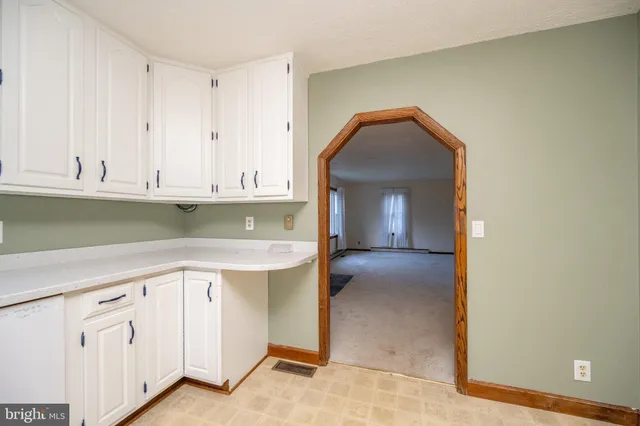 a kitchen with cabinets appliances and white cabinets