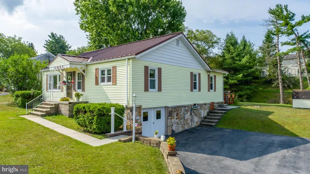 a view of a house with a yard and potted plants