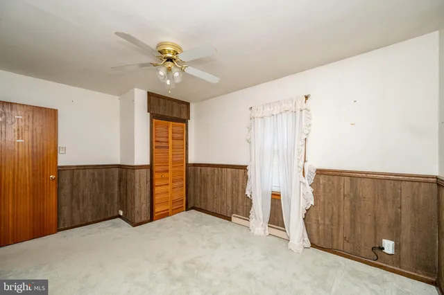 an empty room with closet and fan