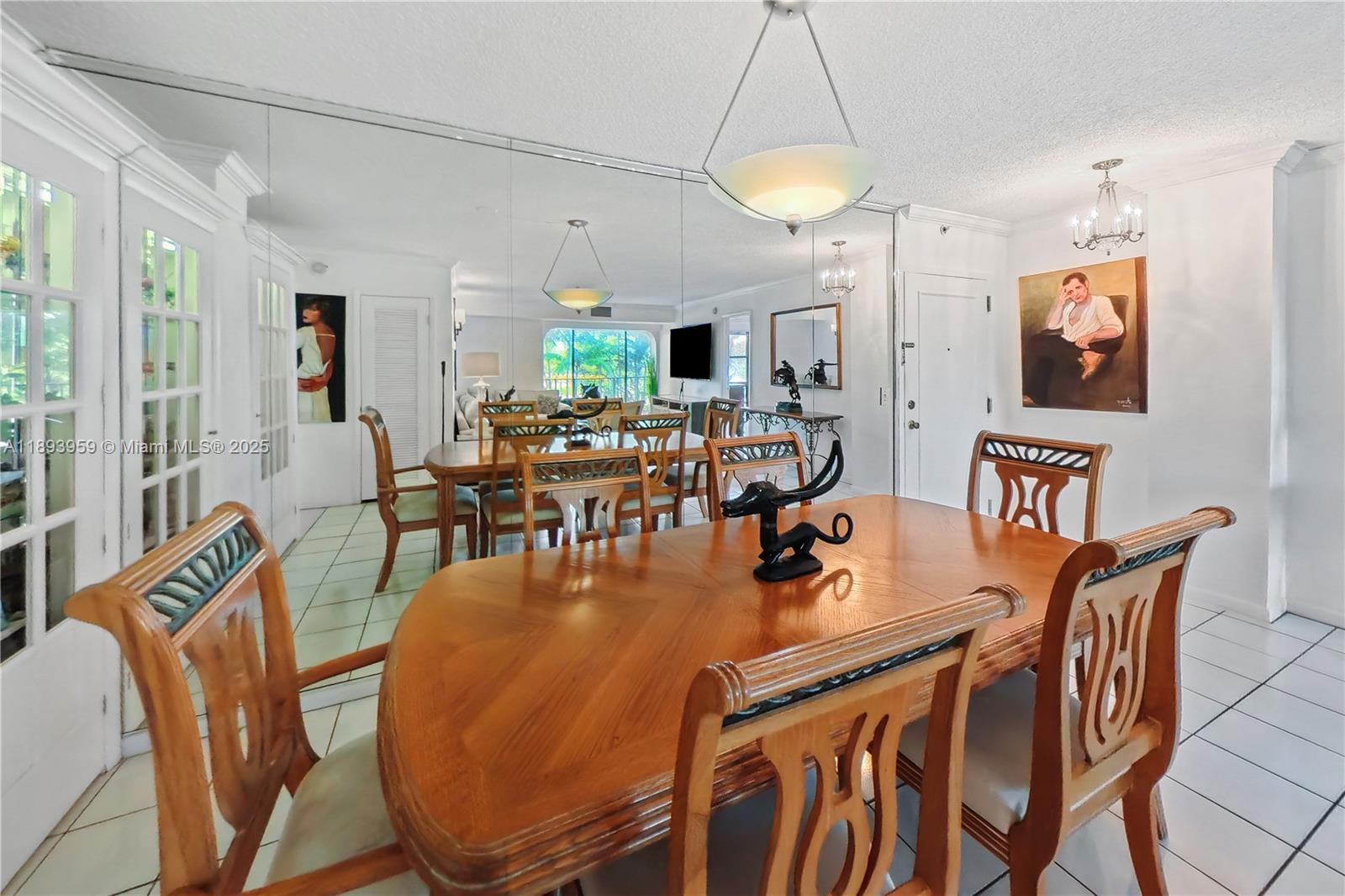 77 Crandon Boulevard, Unit 3C Key Biscayne, FL 33149 - Photo 13 of 34 a dining room with furniture a chandelier and wooden floor