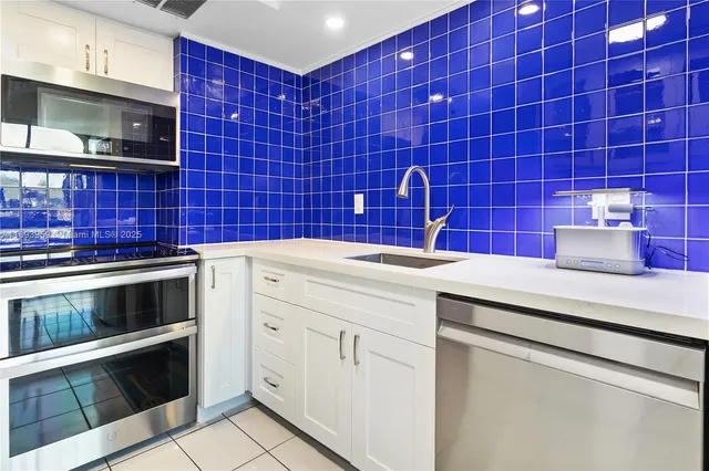 a kitchen with stainless steel appliances kitchen island granite countertop a refrigerator and a sink
