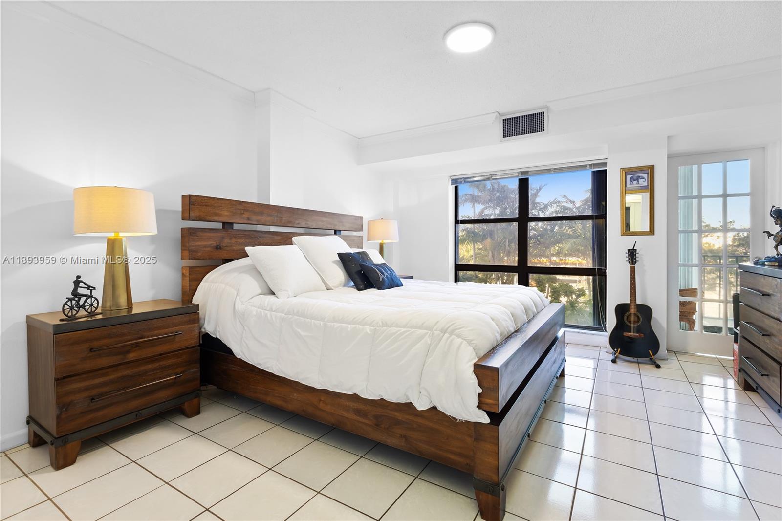 77 Crandon Boulevard, Unit 3C Key Biscayne, FL 33149 - Photo 17 of 34 a bedroom with a bed and a lamp on dresser