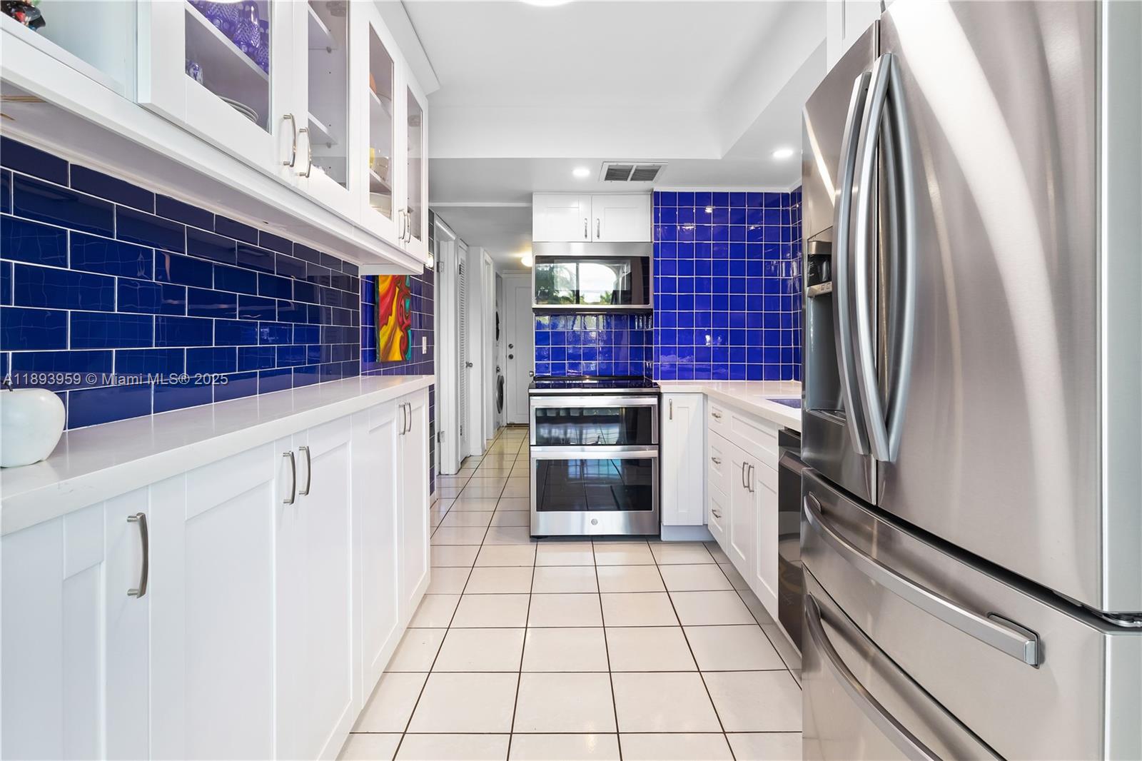 77 Crandon Boulevard, Unit 3C Key Biscayne, FL 33149 - Photo 2 of 34 a kitchen with stainless steel appliances and cabinets