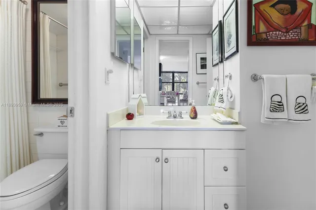 a bathroom with a granite countertop bathtub shower sink vanity and toilet