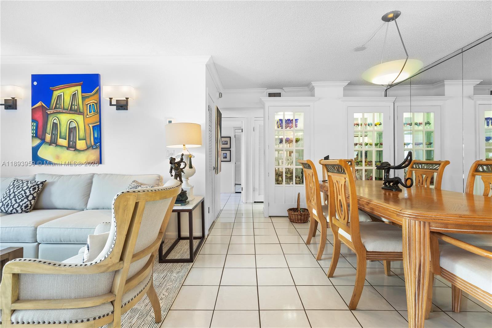 77 Crandon Boulevard, Unit 3C Key Biscayne, FL 33149 - Photo 10 of 34 a living room with furniture and a chandelier