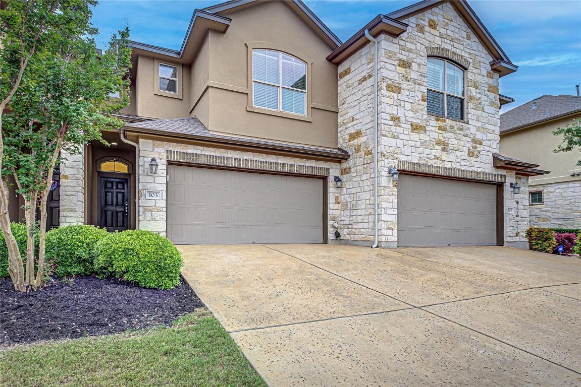 a front view of a house with a yard and garage
