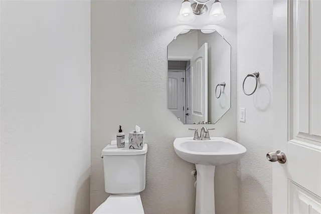 a bathroom with a sink a toilet and mirror