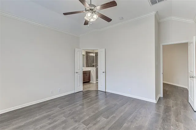 an empty room with wooden floor closet and windows