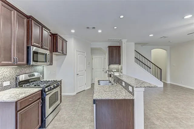 a kitchen with granite countertop a sink a stove and oven