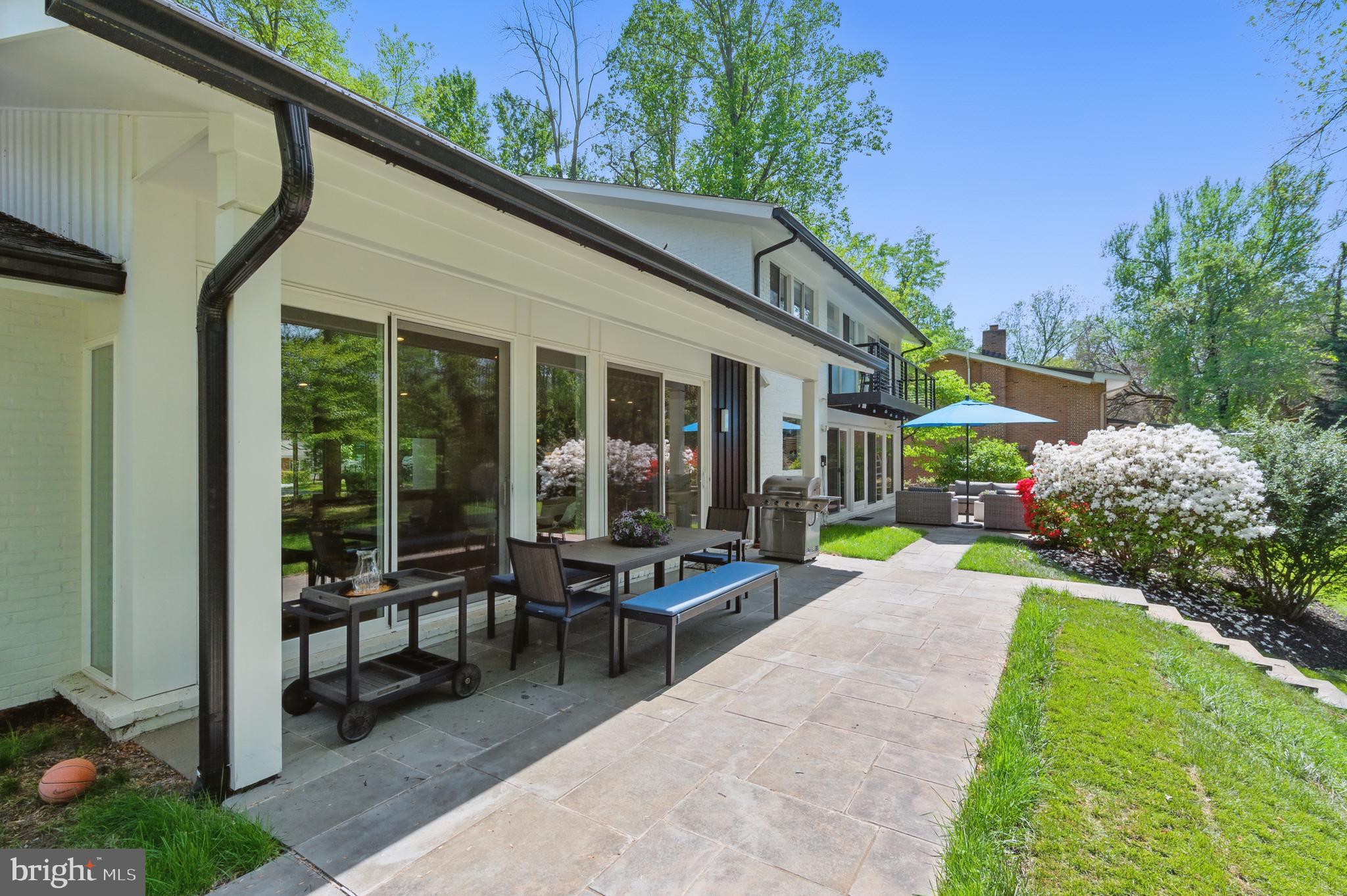 8024 Fenway Road Bethesda, MD 20817 - Photo 31 of 64 a view of a patio with table and chairs potted plants and floor to ceiling window