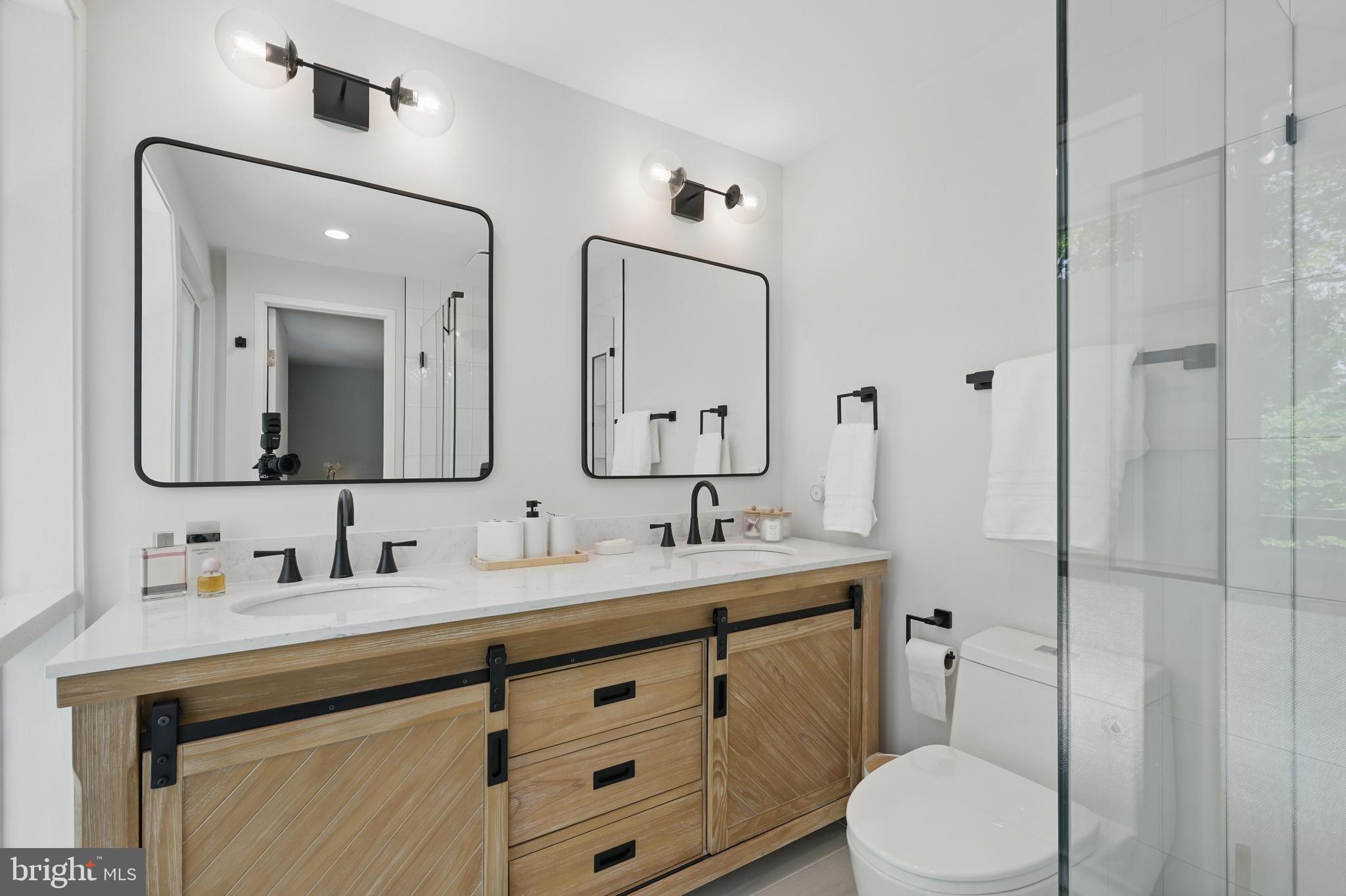 8024 Fenway Road Bethesda, MD 20817 - Photo 42 of 64 a bathroom with a double vanity sink toilet mirror and shower