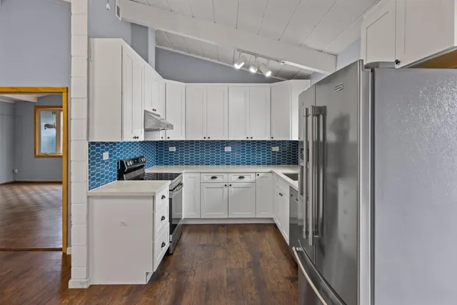 a kitchen with white cabinets and refrigerator