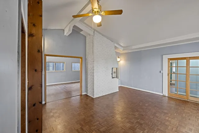 en empty room with windows and fan