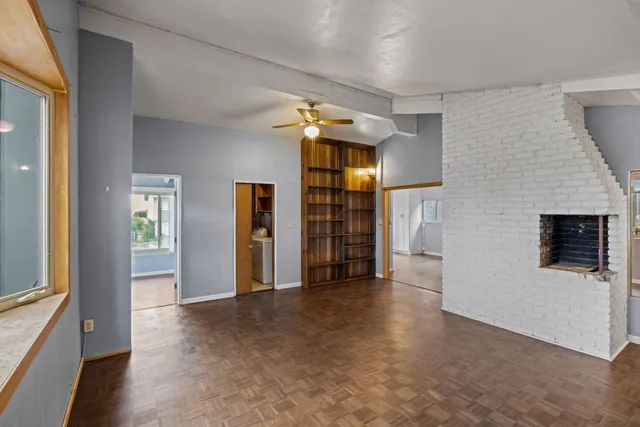 a view of empty room with windows and refrigerator