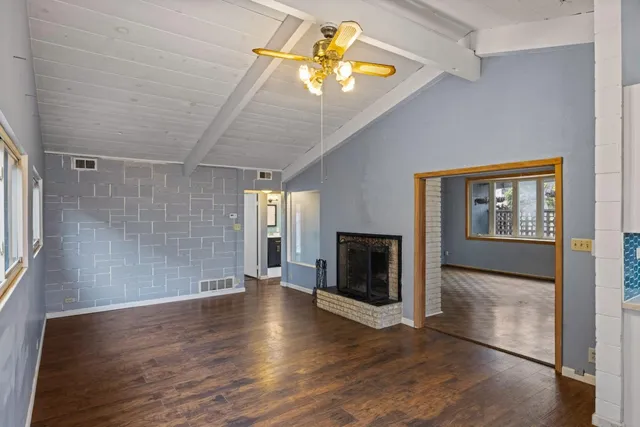 a view of empty room with wooden floor and fireplace