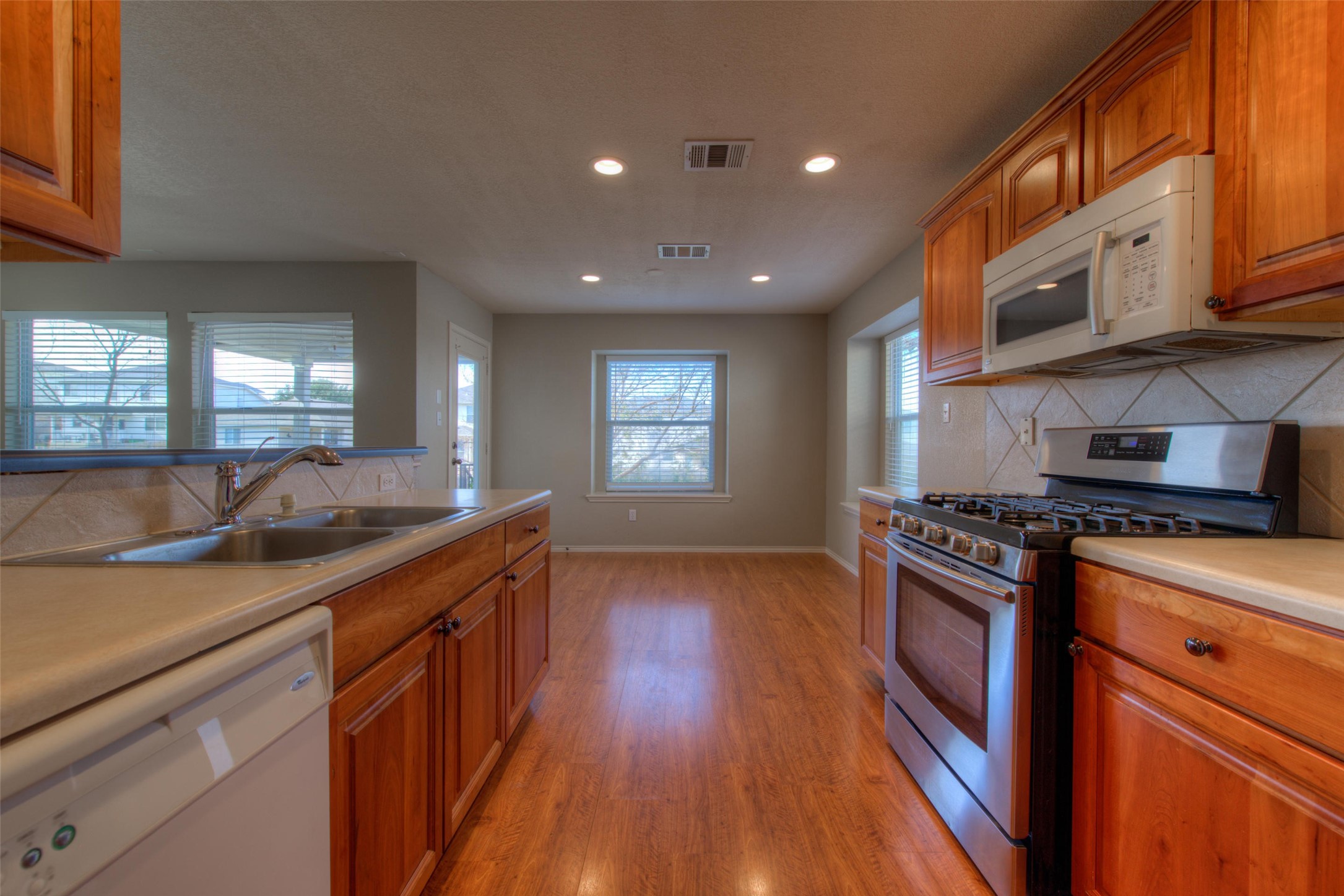 1148 Sundrop Place Round Rock, TX 78665 - Photo 10 of 19 a kitchen with stainless steel appliances granite countertop a sink a stove and a wooden floors