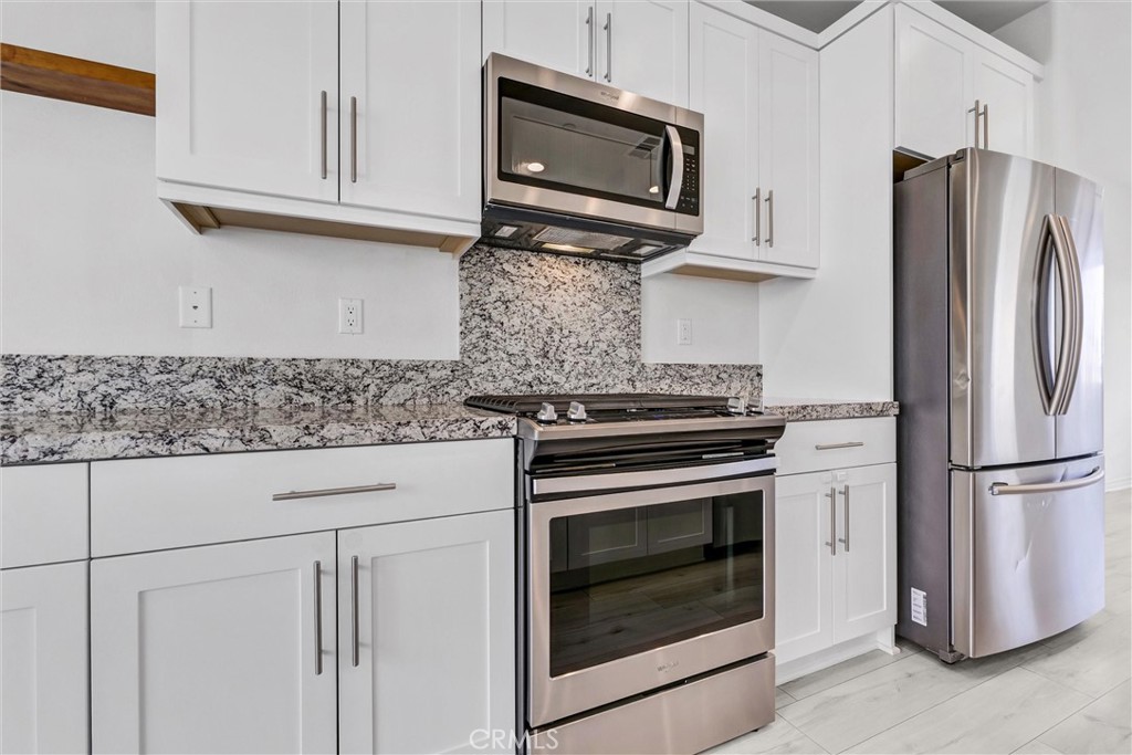 1245 Oliva Court Duarte, CA 91010 - Photo 12 of 23 a kitchen with stainless steel appliances white cabinets white stove a microwave and a refrigerator