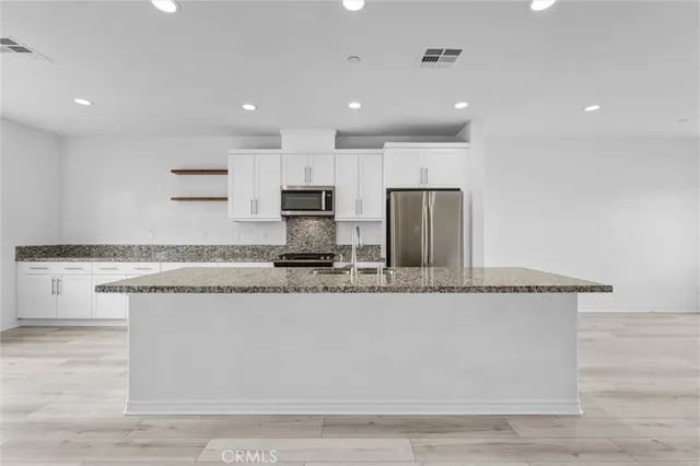 a view of a kitchen with a sink and wooden floor