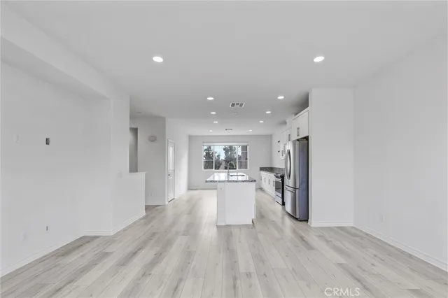 a kitchen with stainless steel appliances white cabinets white stove a microwave and a refrigerator