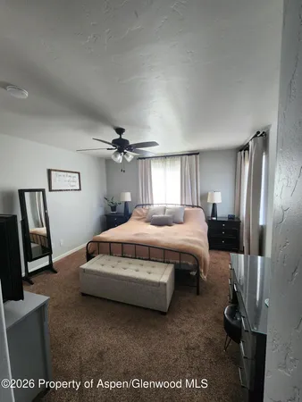 a spacious bedroom with a bed window and a mirror