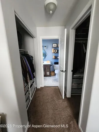 a view of a hallway to rooms and stairs