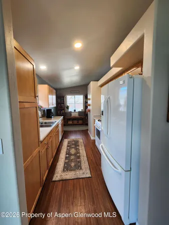 a kitchen with stainless steel appliances a refrigerator a sink a stove and white cabinets