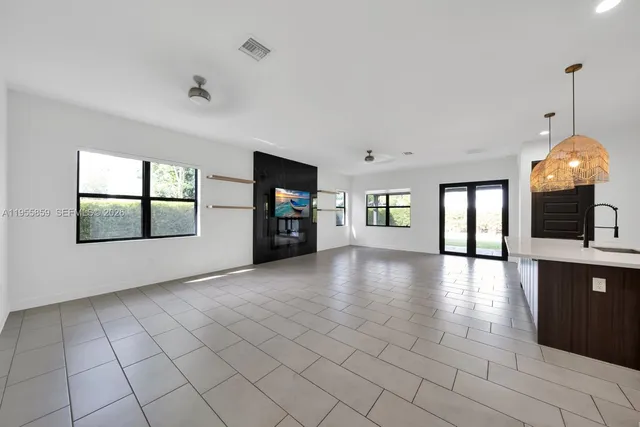 a view of an empty room with window and fire place