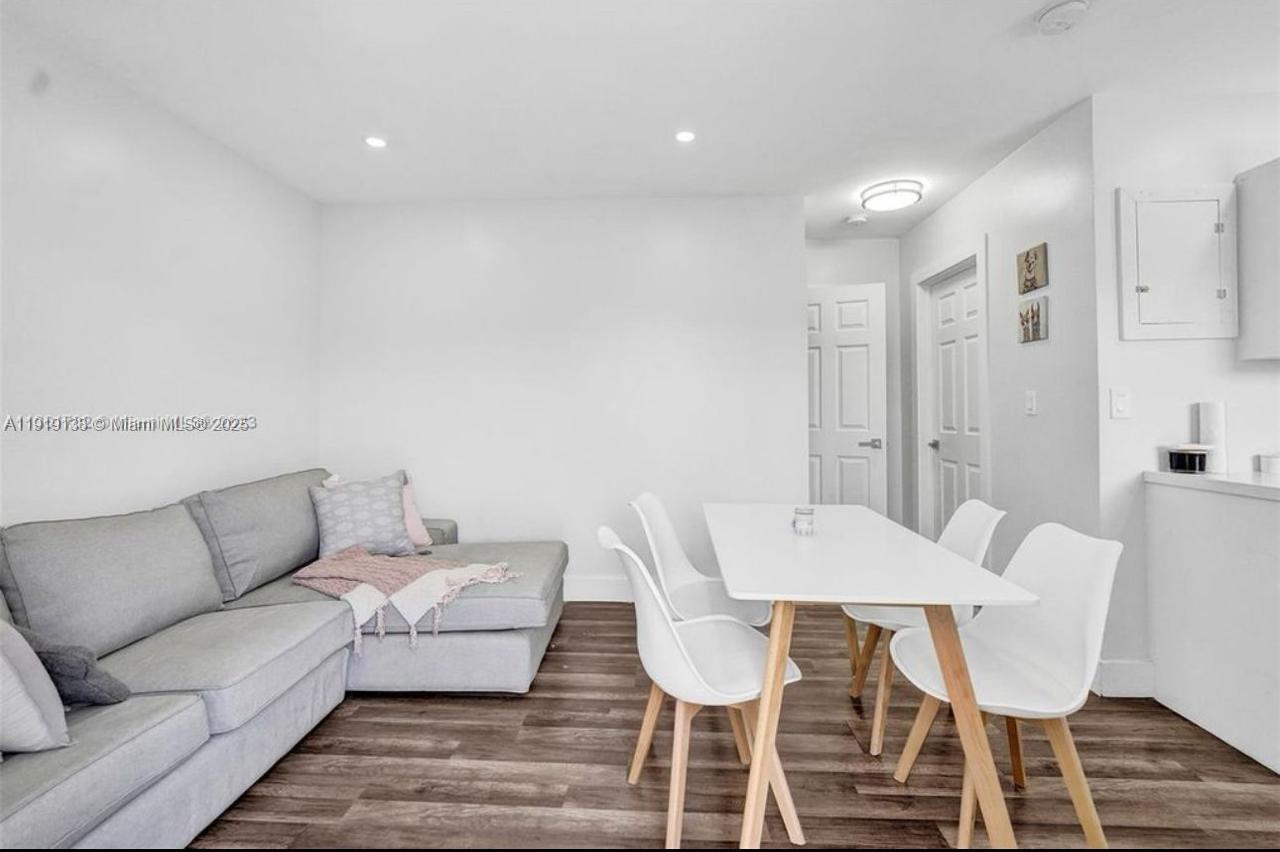 685 Southwest 7th Terrace, Unit 3 Dania Beach, FL 33004 - Photo 4 of 9 a living room with furniture a wooden floor and a chandelier