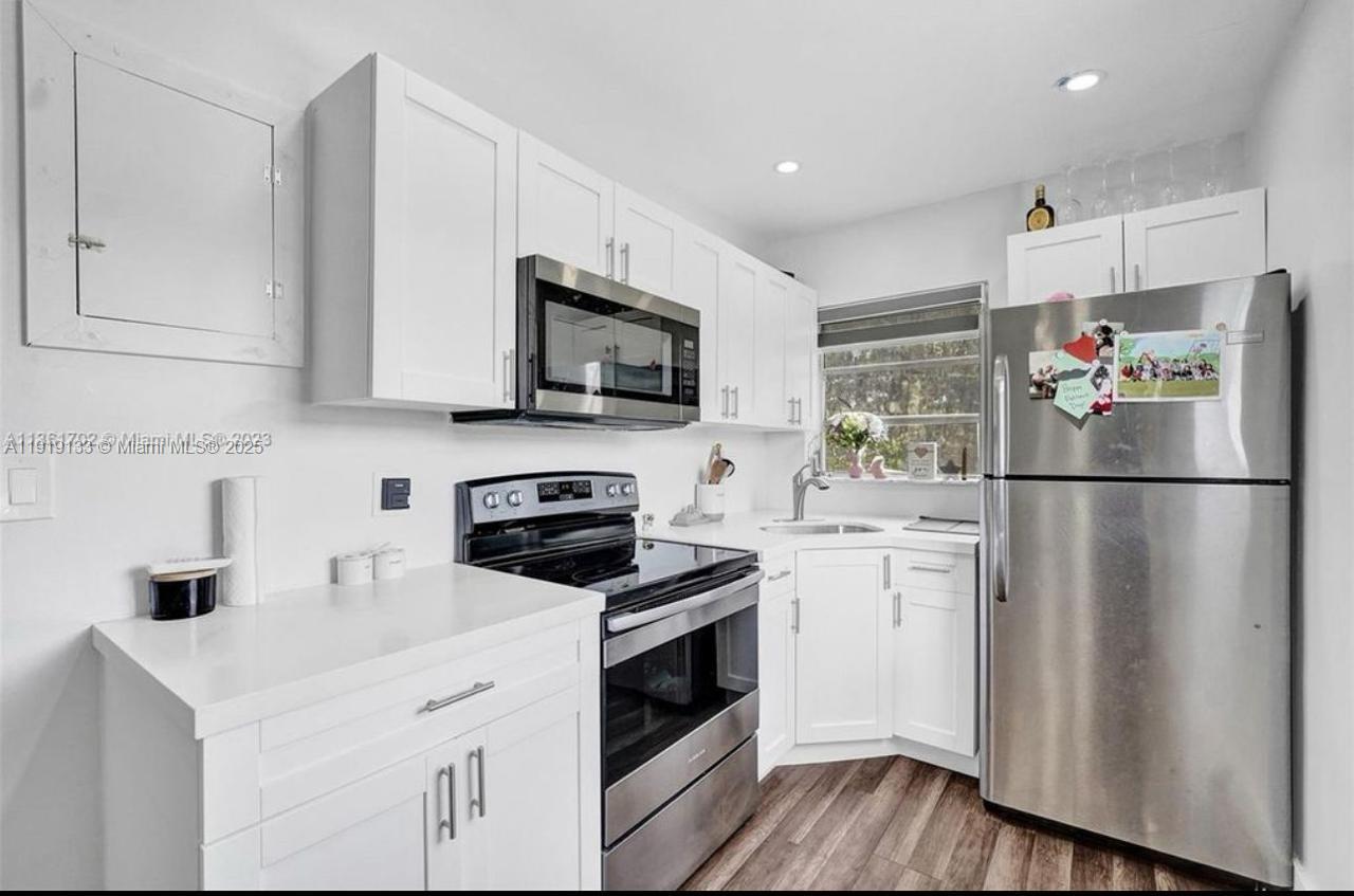 685 Southwest 7th Terrace, Unit 3 Dania Beach, FL 33004 - Photo 6 of 9 a kitchen with stainless steel appliances a refrigerator stove and microwave