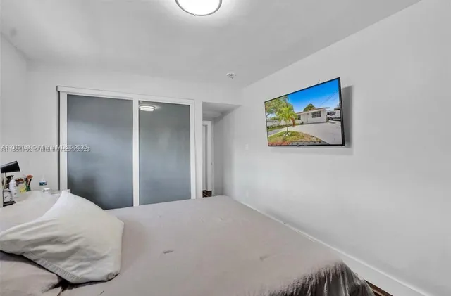 a bedroom with a bed and painting on the wall