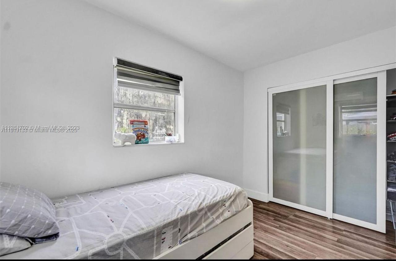 685 Southwest 7th Terrace, Unit 3 Dania Beach, FL 33004 - Photo 8 of 9 a bedroom with a bed and a window