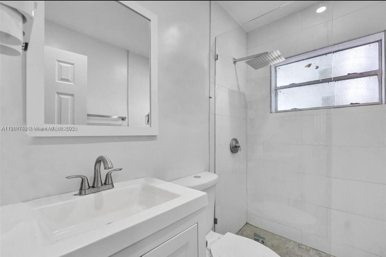 685 Southwest 7th Terrace, Unit 3 Dania Beach, FL 33004 - Photo 9 of 9 a bathroom with a sink toilet and shower