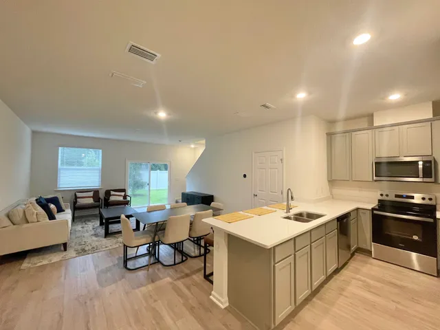 a room with a table chairs and a refrigerator