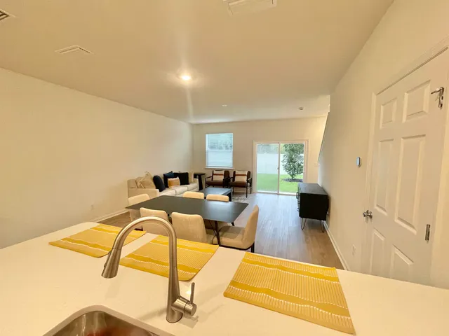 a kitchen with a refrigerator a sink and white cabinets